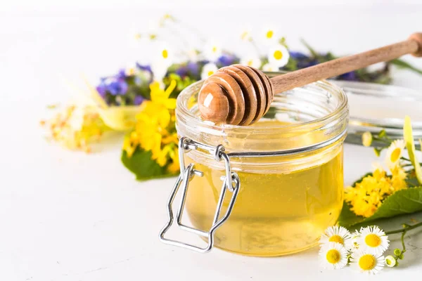 Doğal tatlım. Beyaz arka plan üzerinde yabani otlar bir cam kavanoza tatlım. Yakın çekim.