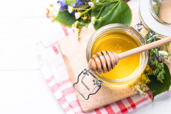 Doğal tatlım. Beyaz arka plan üzerinde yabani otlar bir cam kavanoza tatlım. Üstten görünüm.