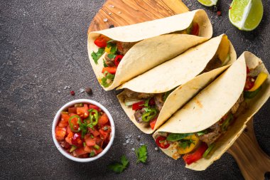 Sebze ve taş masada salsa Meksika domuz tacos. Geleneksel Latin Amerika Gıda. Kopya alanı ile üstten görünüm.