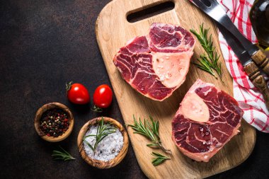 Kesme tahtası üzerinde ham sığır eti biftek osso bucco.