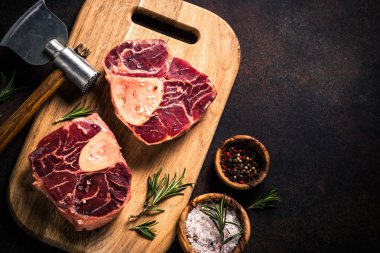 Kesme tahtası üzerinde ham sığır eti biftek osso bucco.