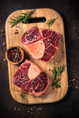 Kesme tahtası üzerinde ham sığır eti biftek osso bucco.