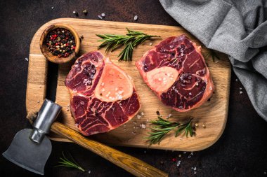 Kesme tahtası üzerinde ham sığır eti biftek osso bucco.