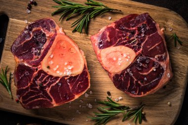 Kesme tahtası üzerinde ham sığır eti biftek osso bucco.