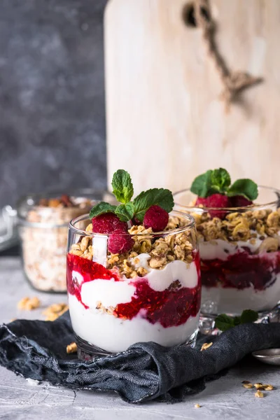 Layered dessert with yogurt, granola, jam and raspberries. — Stock Photo, Image