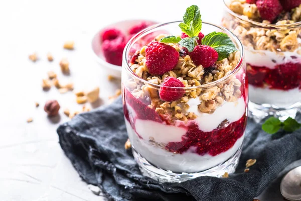 Yogurt parfafait with granola and raspberries in glass. — Stock Photo, Image