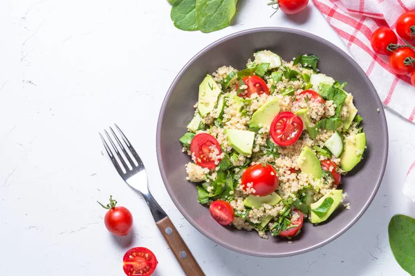 Quinoa salata ıspanak, avokado ve domates ile üst görünümü.