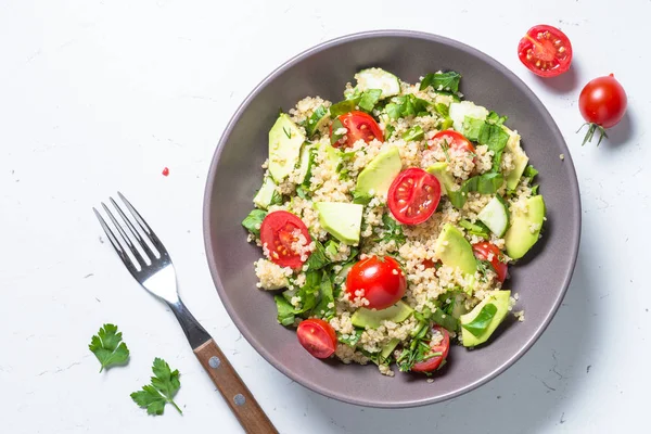 Quinoa salata ıspanak, avokado ve domates ile üst görünümü.