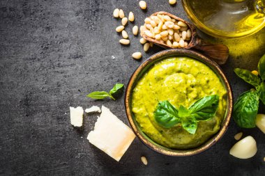 Pesto sos karanlık taş masada malzemelerle. 