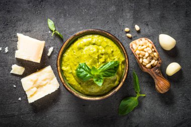 Pesto sos karanlık taş masada malzemelerle. 