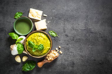 Pesto sos karanlık taş masada malzemelerle. 