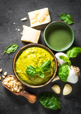 Pesto sos karanlık taş masada malzemelerle. 