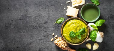 Pesto sos karanlık taş masada malzemelerle. 