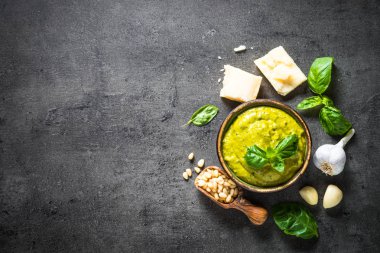 Pesto sos karanlık taş masada malzemelerle. 