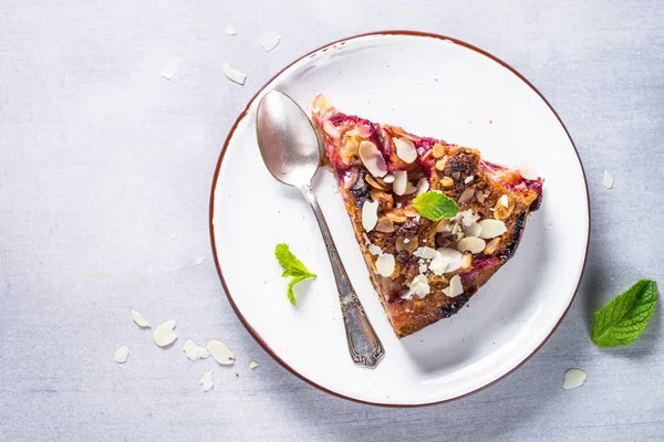 Cake with plums and almond flake. — Stock Photo, Image