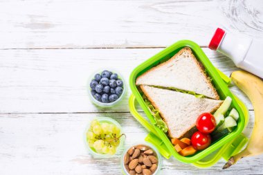 Beslenme çantası sandviç, sebze, yoğurt, fındık ve çilek ile.