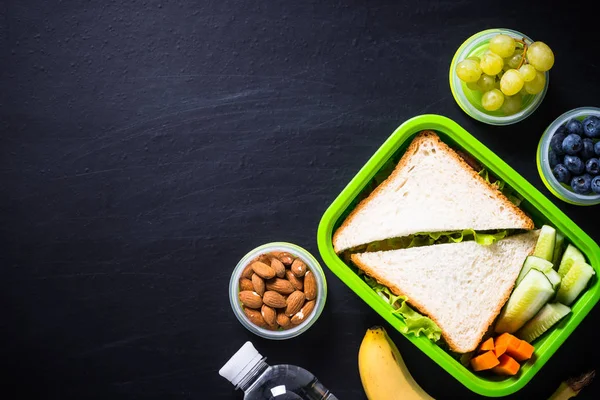 Lancheira com sanduíche, legumes, banana, água, nozes e ber — Fotografia de Stock