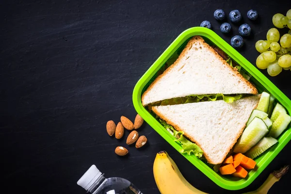 Lancheira com sanduíche, legumes, banana, água, nozes e ber — Fotografia de Stock