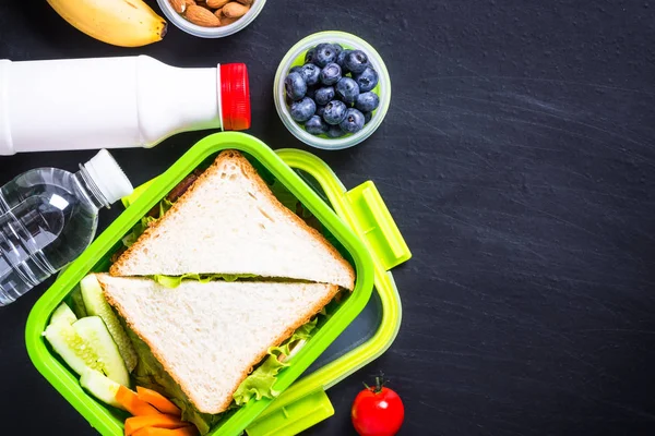 Pranzo al sacco con panino, verdure, banana, acqua, noci e ber — Foto Stock