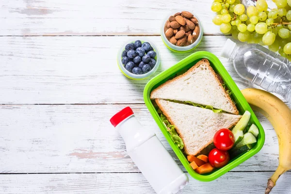 Pudełko na lunch z kanapkami, warzywa, jogurt, orzechy i jagody. — Zdjęcie stockowe