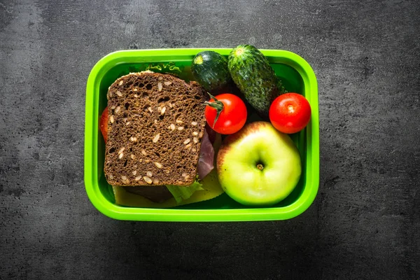 Ebéd-box, szendvics, zöldség, banán, víz, dió és ber — Stock Fotó