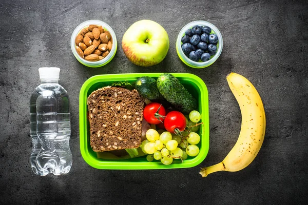 Lunch box with sandwich, vegetables, banana, water, nuts and ber — Stock Photo, Image