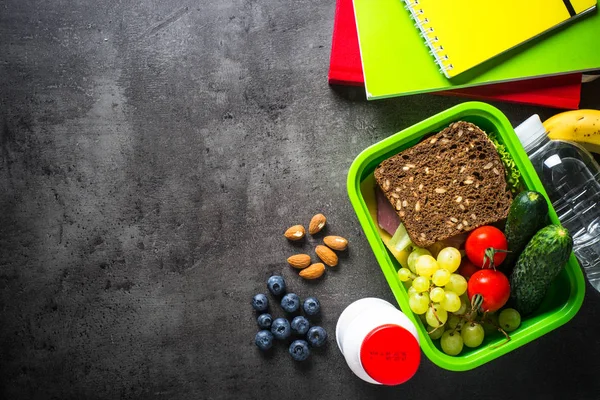 Almoço escolar e artigos de papelaria sobre fundo preto . — Fotografia de Stock