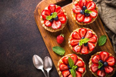 Çilekli tart karanlık masada. Üstten görünüm.