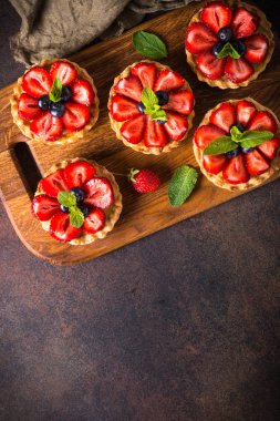 Çilekli tart karanlık masada. Üstten görünüm.