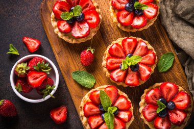 Çilekli tart karanlık masada. Üstten görünüm.