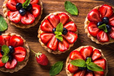 Çilekli tart karanlık masada. Üstten görünüm.