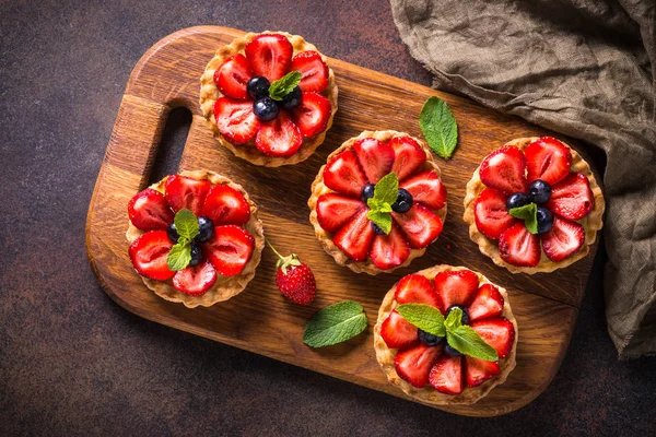 Çilekli tart karanlık masada. Üstten görünüm.