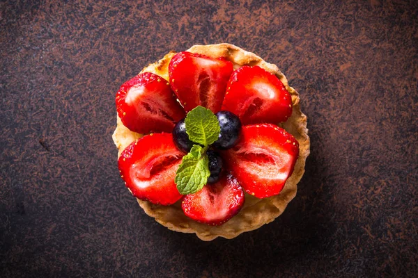 Çilekli tart karanlık masada. Üstten görünüm.