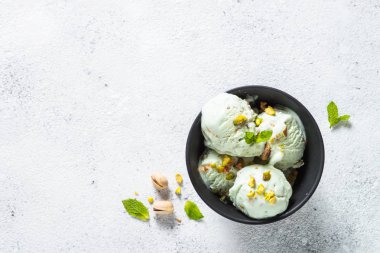 Antep fıstığı dondurma kase beyaz taş masada.