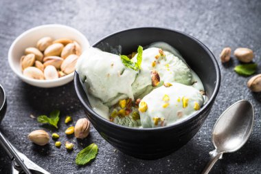 Antep fıstığı dondurma kase siyah taş masada.