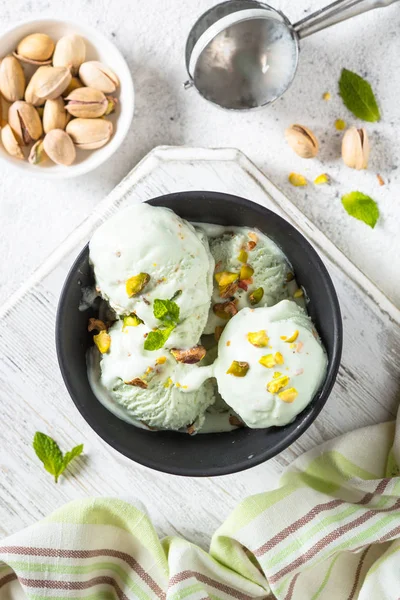 Pistagenötter glass i skål på vitt stenbord. — Stockfoto