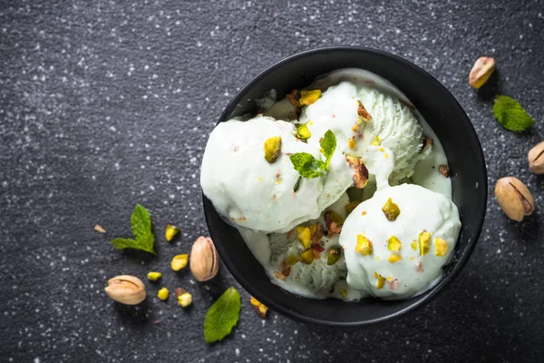 Pistazien-Eis in Schüssel auf schwarzem Stein-Tisch. — Stockfoto