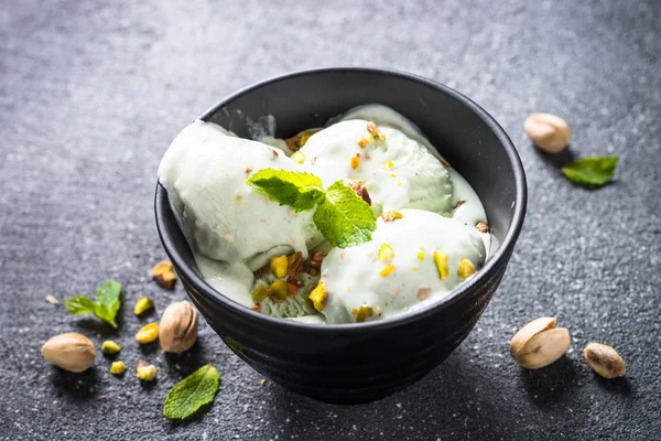 Pistazien-Eis in Schüssel auf schwarzem Stein-Tisch. — Stockfoto