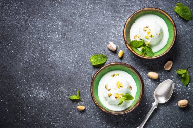 Antep fıstığı dondurma kase siyah taş masada.