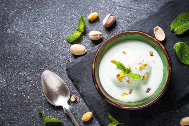 Antep fıstığı dondurma kase siyah taş masada.