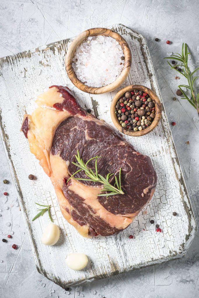 Beef steak ribeye with herbs and spices top view.