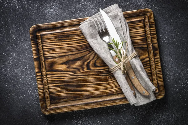Dřevěný talíř a příbory na kamenný stůl horní pohled. — Stock fotografie
