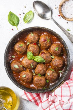 Beyaz masa üzerinde domates soslu köfte.