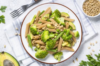 Vejetaryen Makarna. Brokoli, avakado, yeşil fasulye, bezelye ve çam fıstığı ile tam buğday makarna penne.