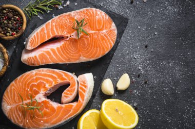 Somon bifteği çiğ balık pişirmeye hazır. Siyah tahta üzerinde üst görünüm.