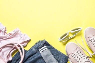 Kadın moda bez set - pembe ayakkabı, üst ve sarı zemin üzerine kot. Üstten görünüm kopya alanı.