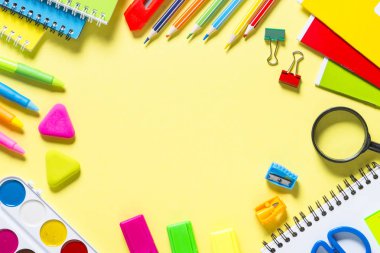 Sarı zemin üzerine okul ve ofis sstationery. Defter, Not defteri, kalem, kalem, Büyüteç, ataç ve şeyler. Kopya alanı ile üstten görünüm.