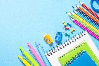Geri okul kavramı. Defter, Not defteri, kalem, kalem, ataç ve şeyler. Kopya alanı ile üstten görünüm.