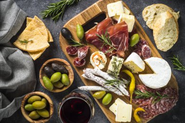 Meze kurulu dilimlenmiş et, jambon, salam, peynir, zeytin ve kırmızı şarap ile. Kopya alanı ile üstten görünüm.