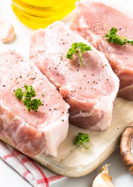 Domuz eti biftek, dilim domuz loin otlar ve baharatlar ile beyaz.
